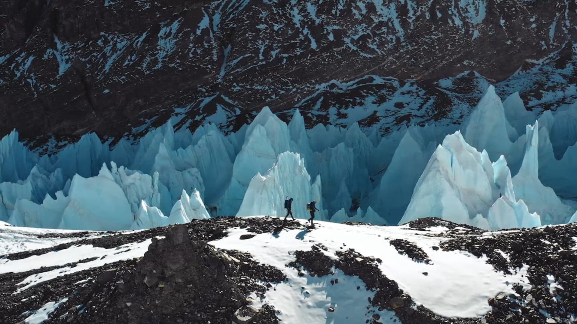 Cory Richards walking over a mountain with snow