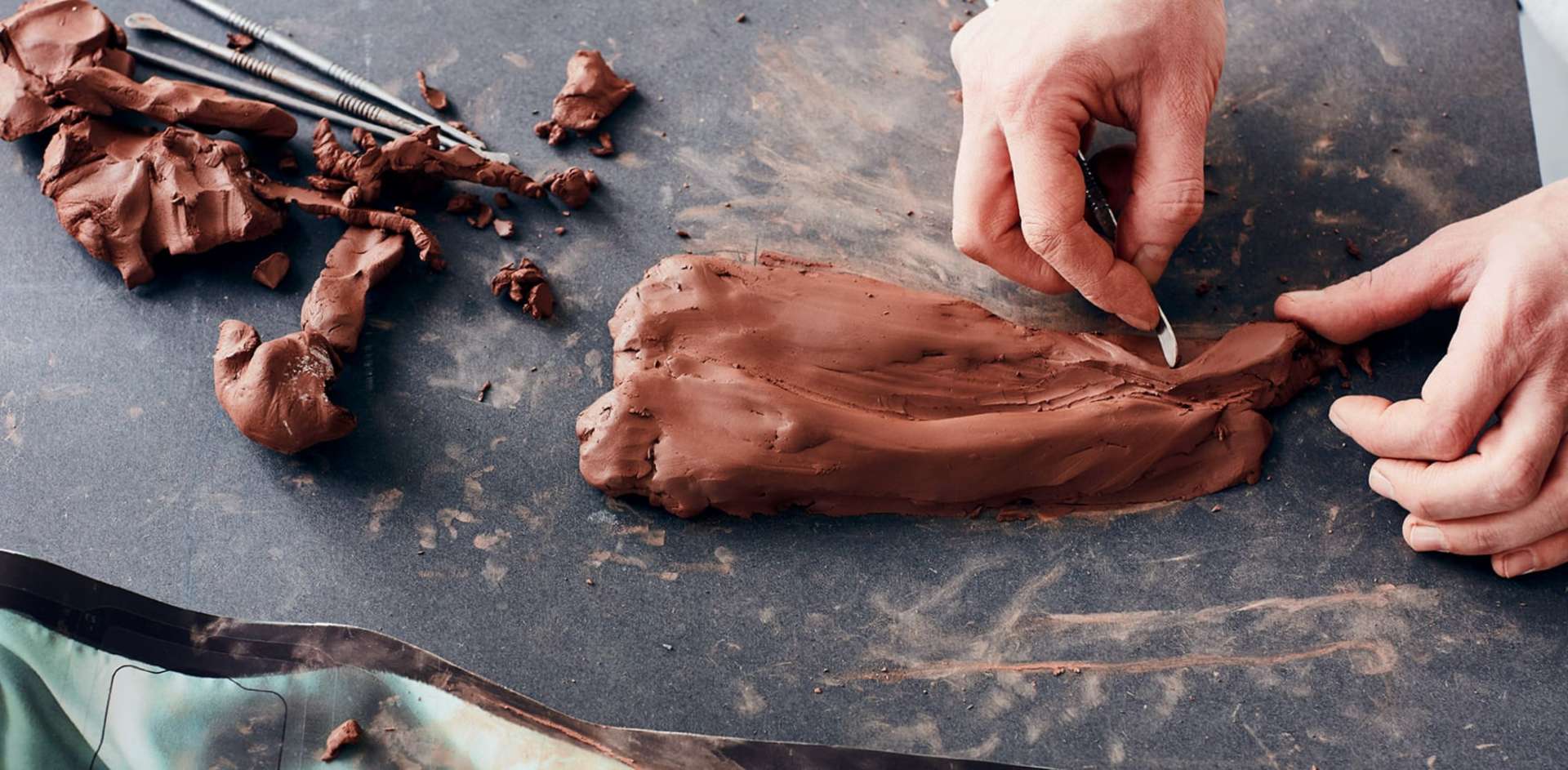 A pair of handles carving out clay