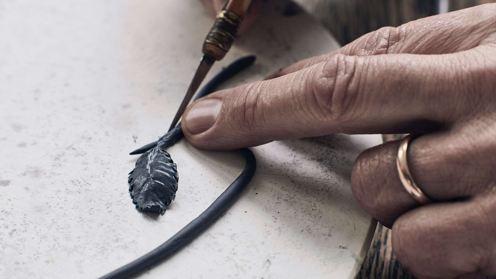 A craftsman at work on one of the porcelain leaves that will make up this Bespoke Phantom Gallery