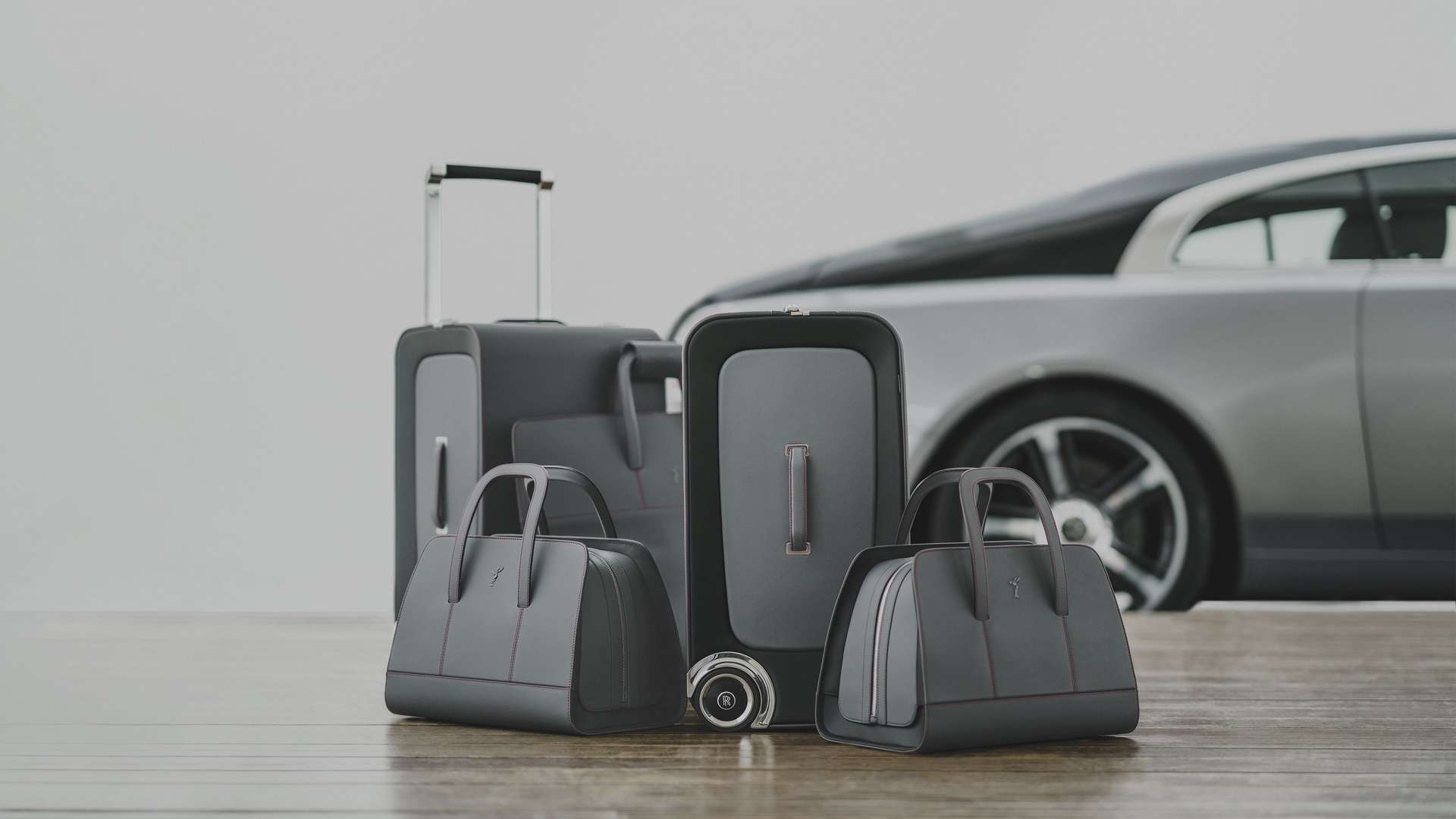 Multiple Rolls-Royce luggage bags in front of a Wraith motor car.