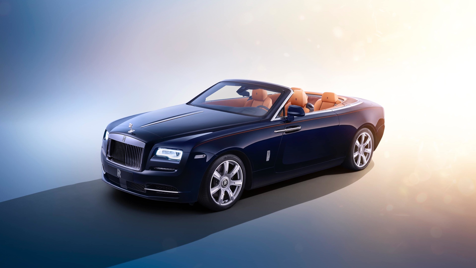 A dark blue Rolls-Royce Motor Cars Dawn with the silver finish wheel style 603 on a sunrise background