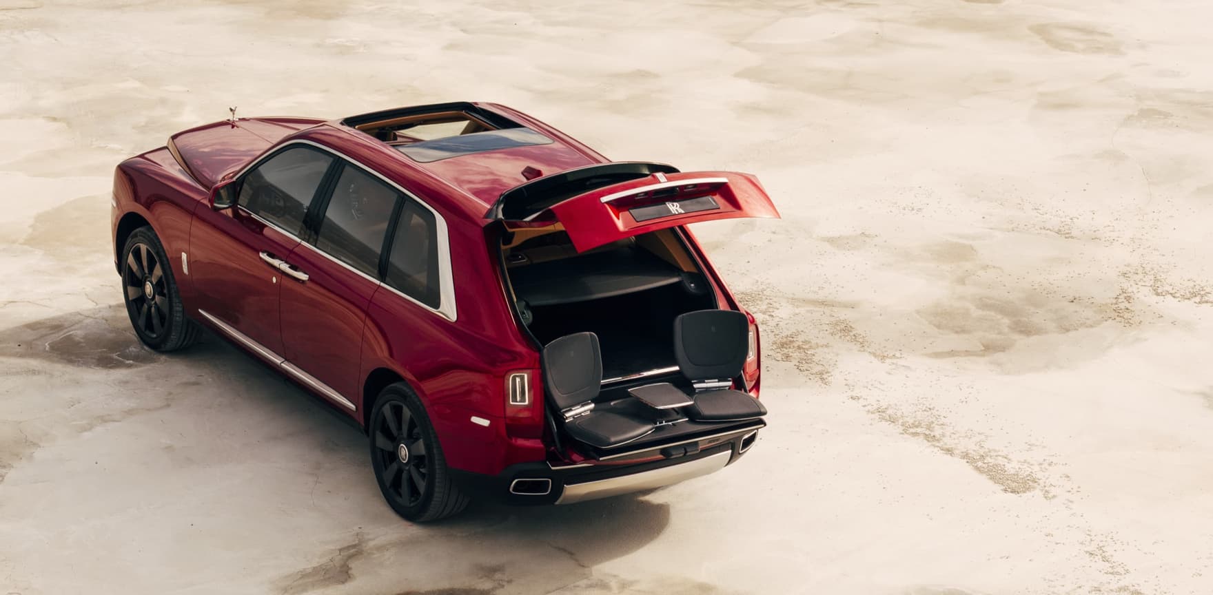 Aerial rear view of stationary Rolls-Royce Cullinan motor car with rear door open revealing the bespoke Cullinan Viewing Suite