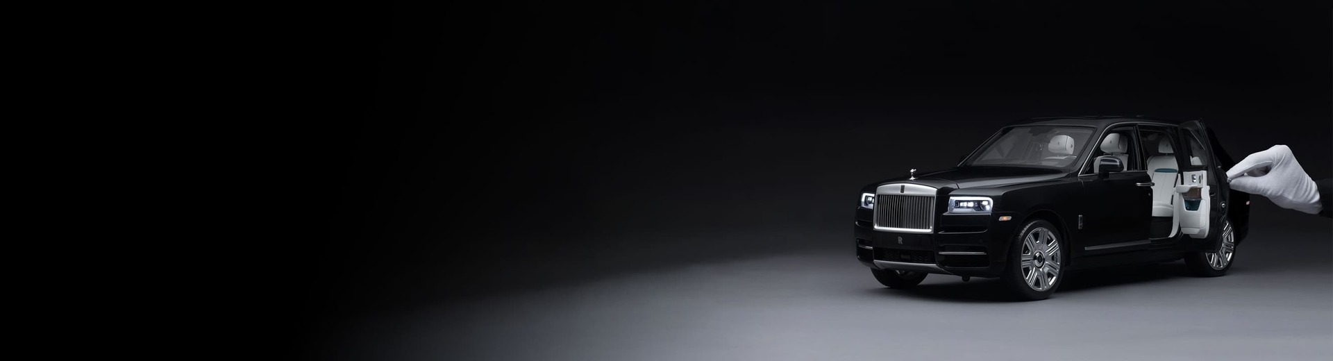 1:8 scale model of a Rolls-Royce motor car with hand holding miniature door open