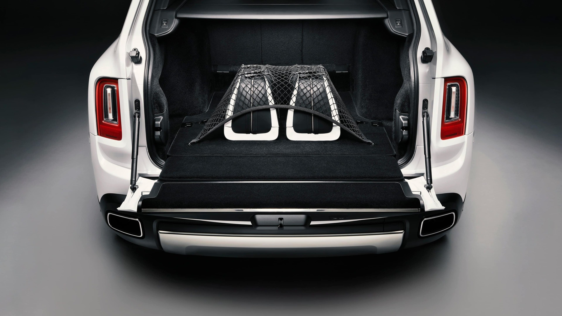 Rolls-Royce Cullinan motor car with rear door open revealing durable luggage net and luggage