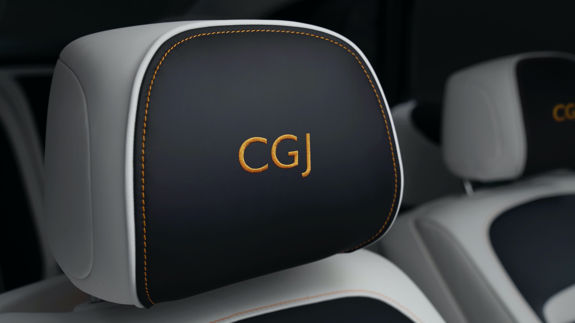Rolls-Royce motor car black headrests with elegantly embroidered personalised lettering in orange saying C.G.J.