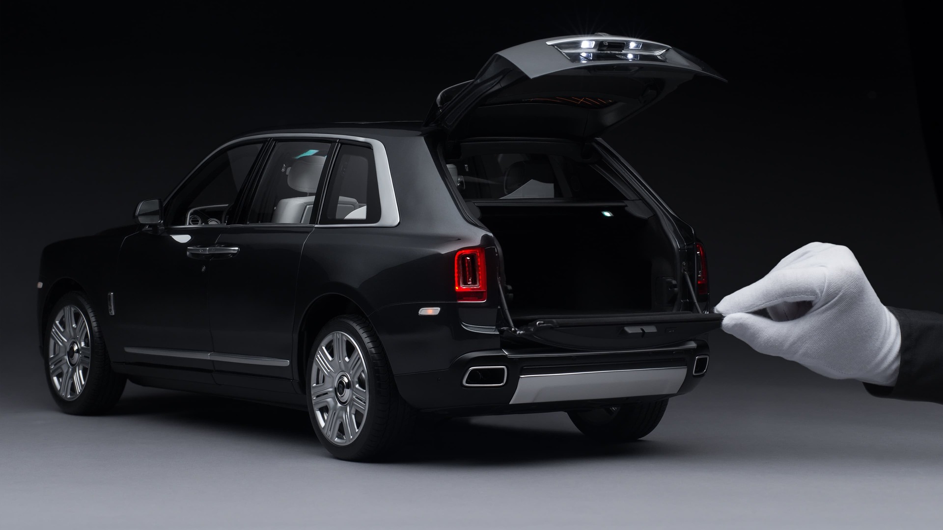 1:8 scale model of the Rolls-Royce Cullinan motor car with hand opening the trunk