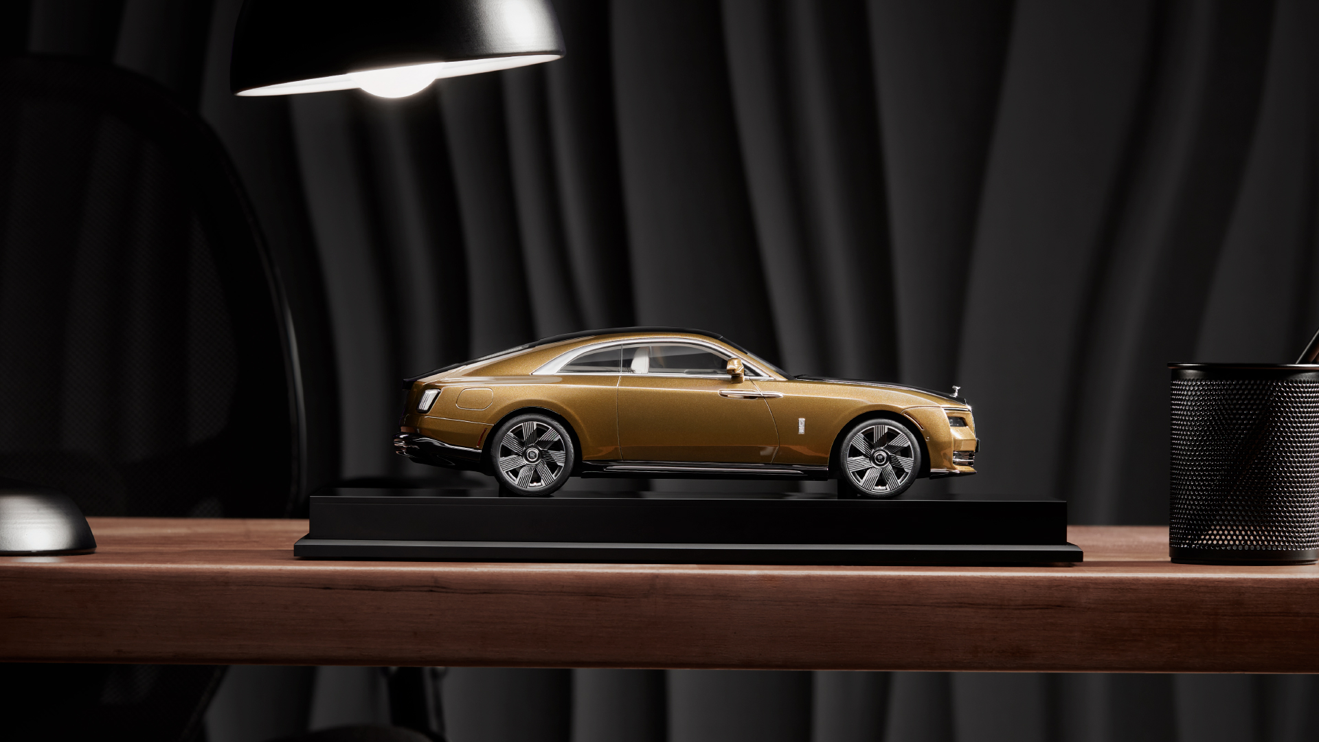 Side view of a a replica of the Rolls Royce Spectre model in gold colour