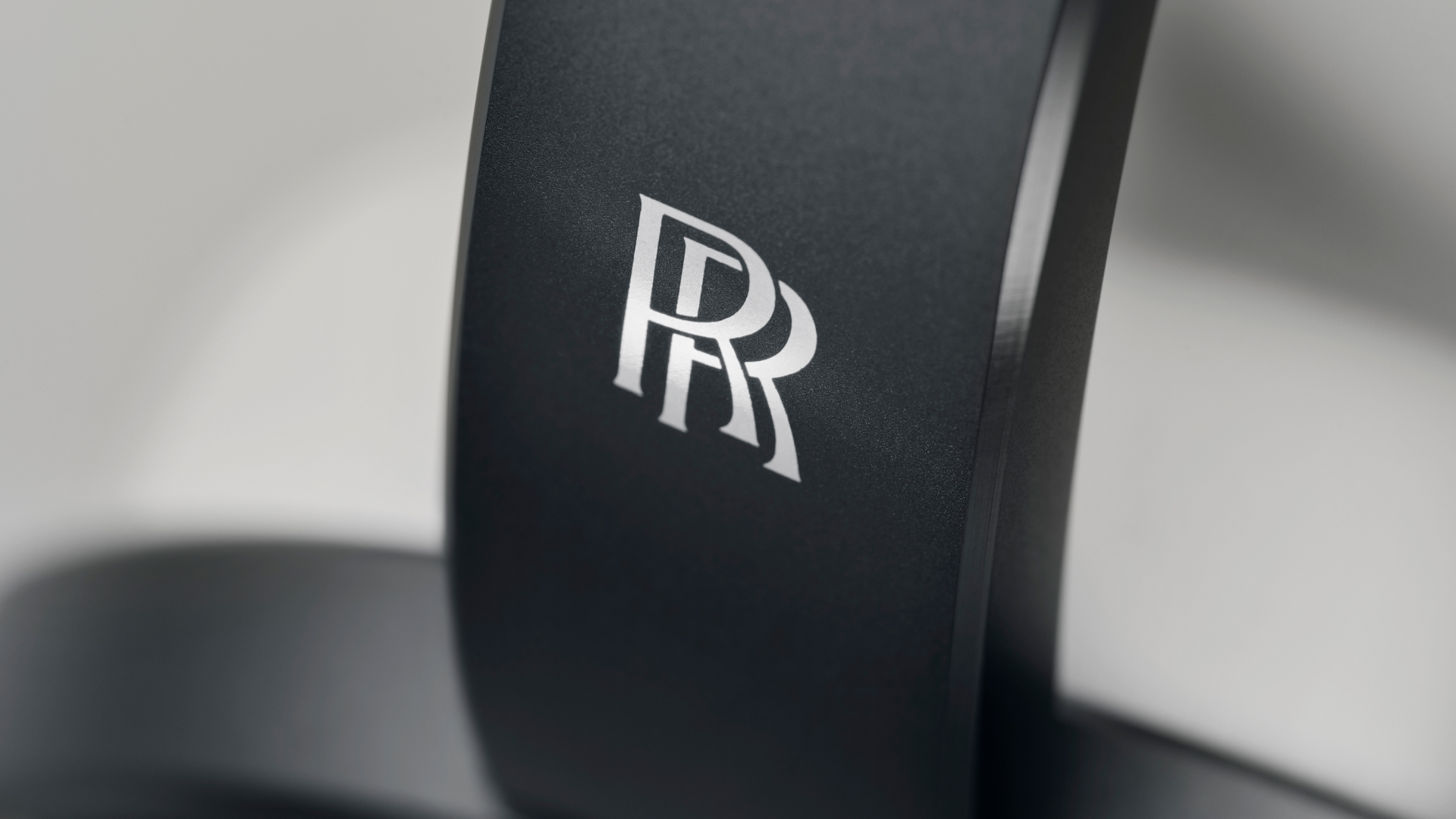 Detailed view of the Rolls-Royce monogram on the bluetooth headphones