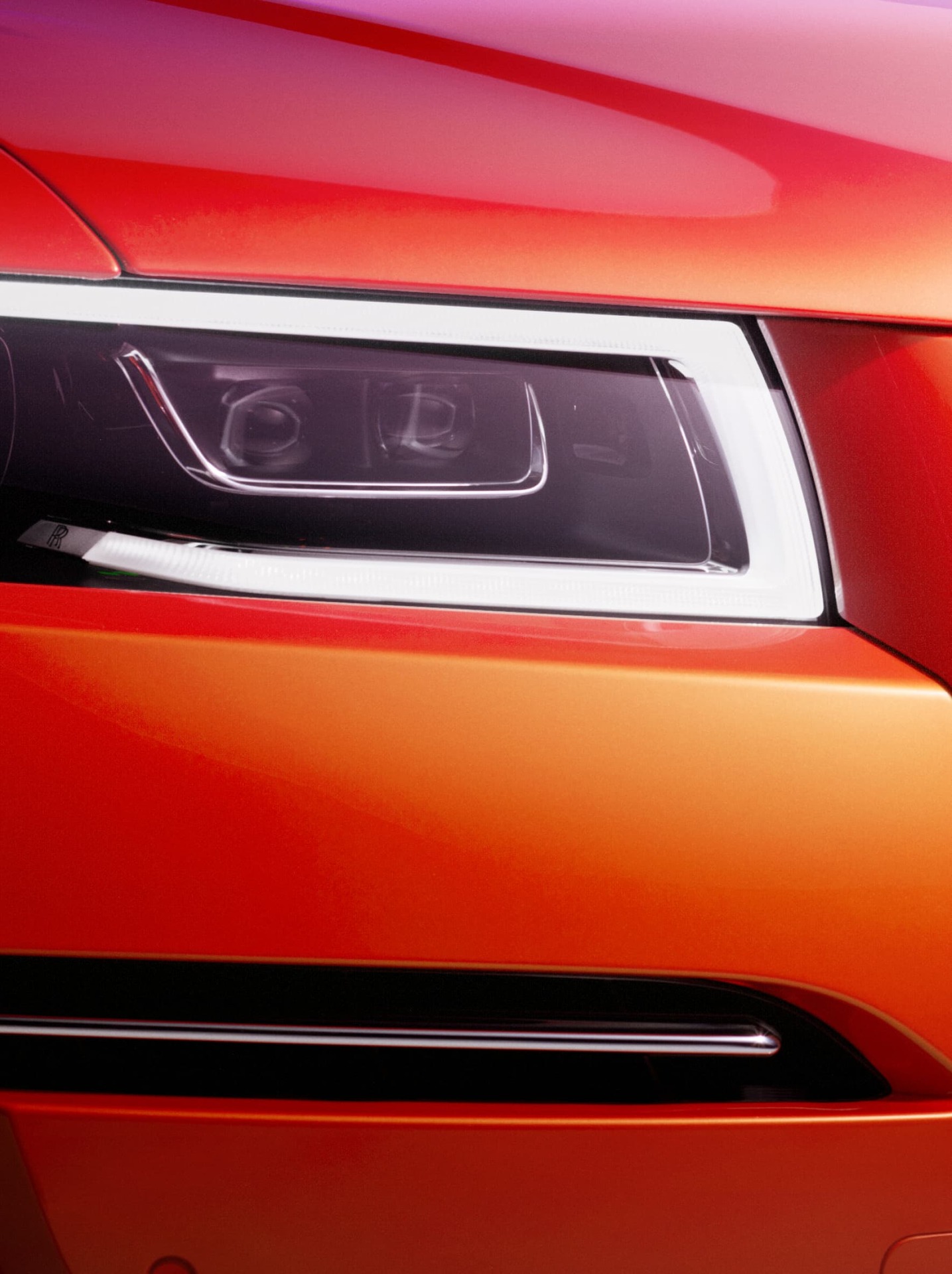 close up of the front headlight turned on of the Orange Metallic Ghost