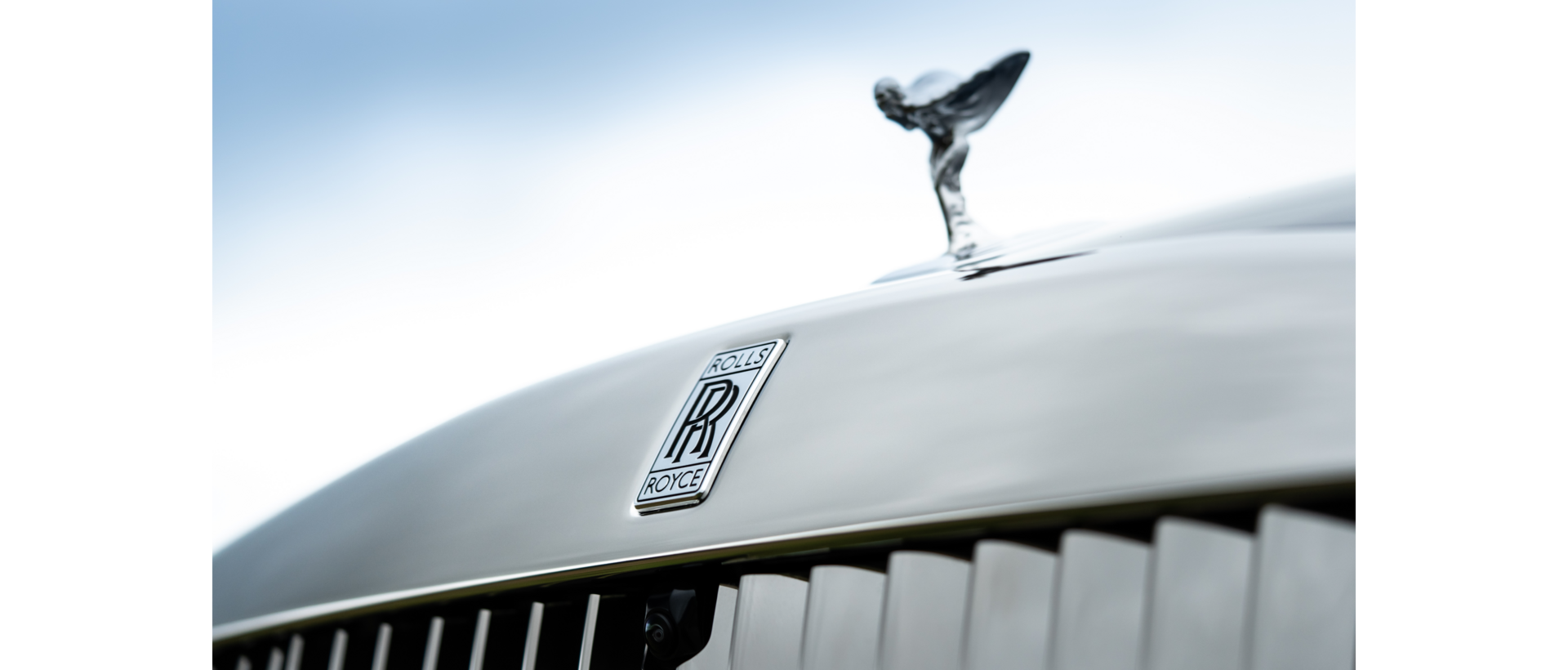 Close up shot showing the silver spirit of ecstasy, and silver Rolls Royce badge. 