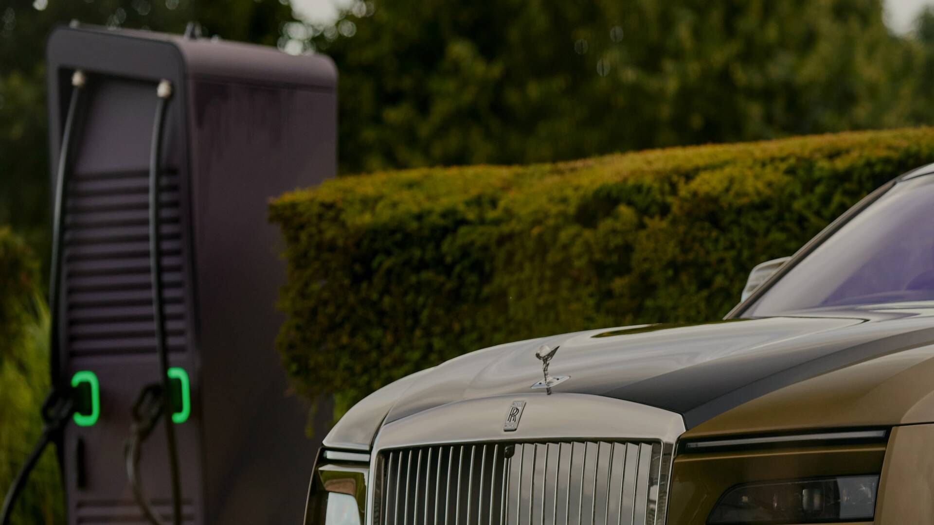 Up close of the Spectre bonnet and grille with the charging station in the distance