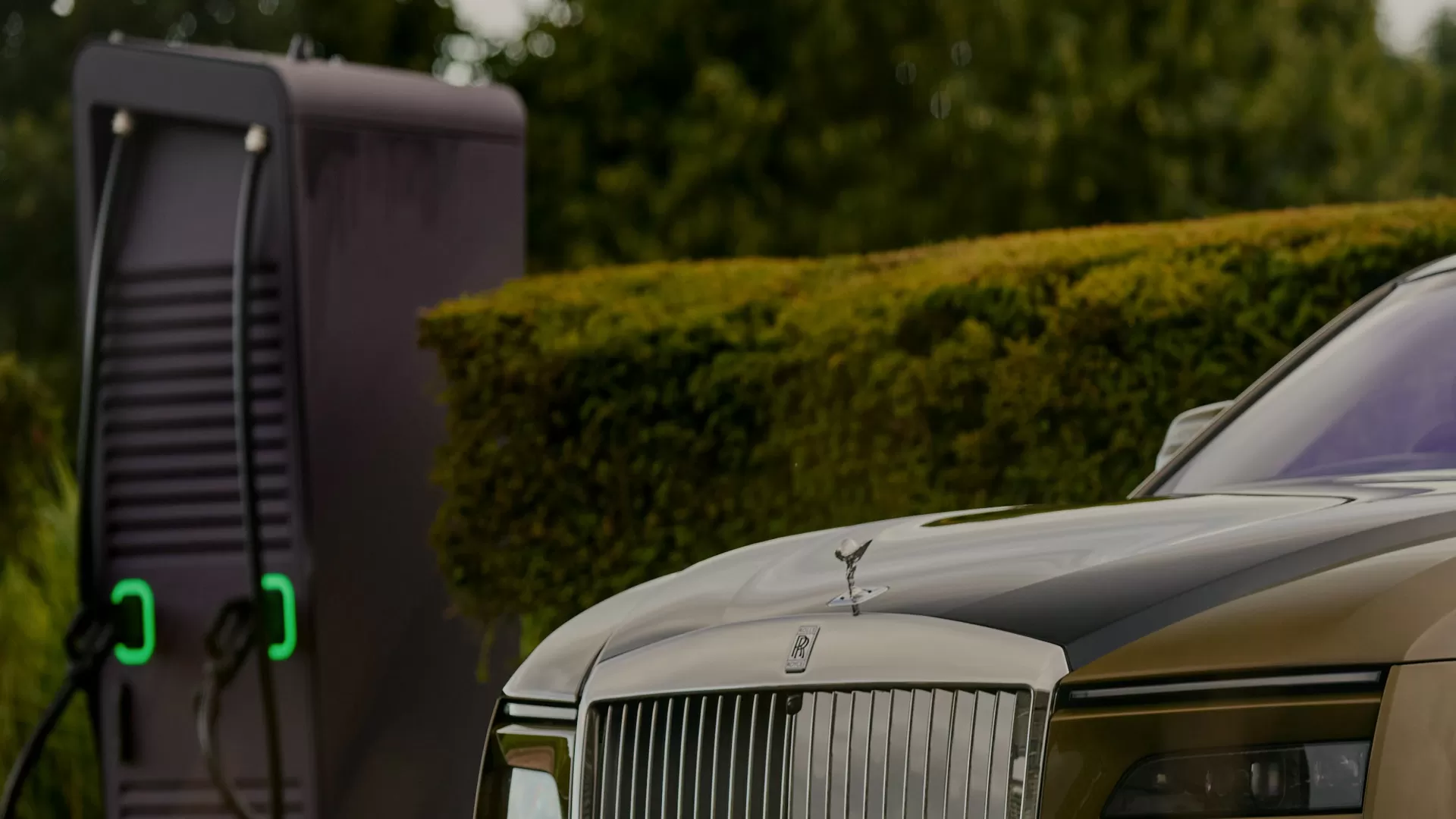 Up close of the Spectre bonnet and grille with the charging station in the distance