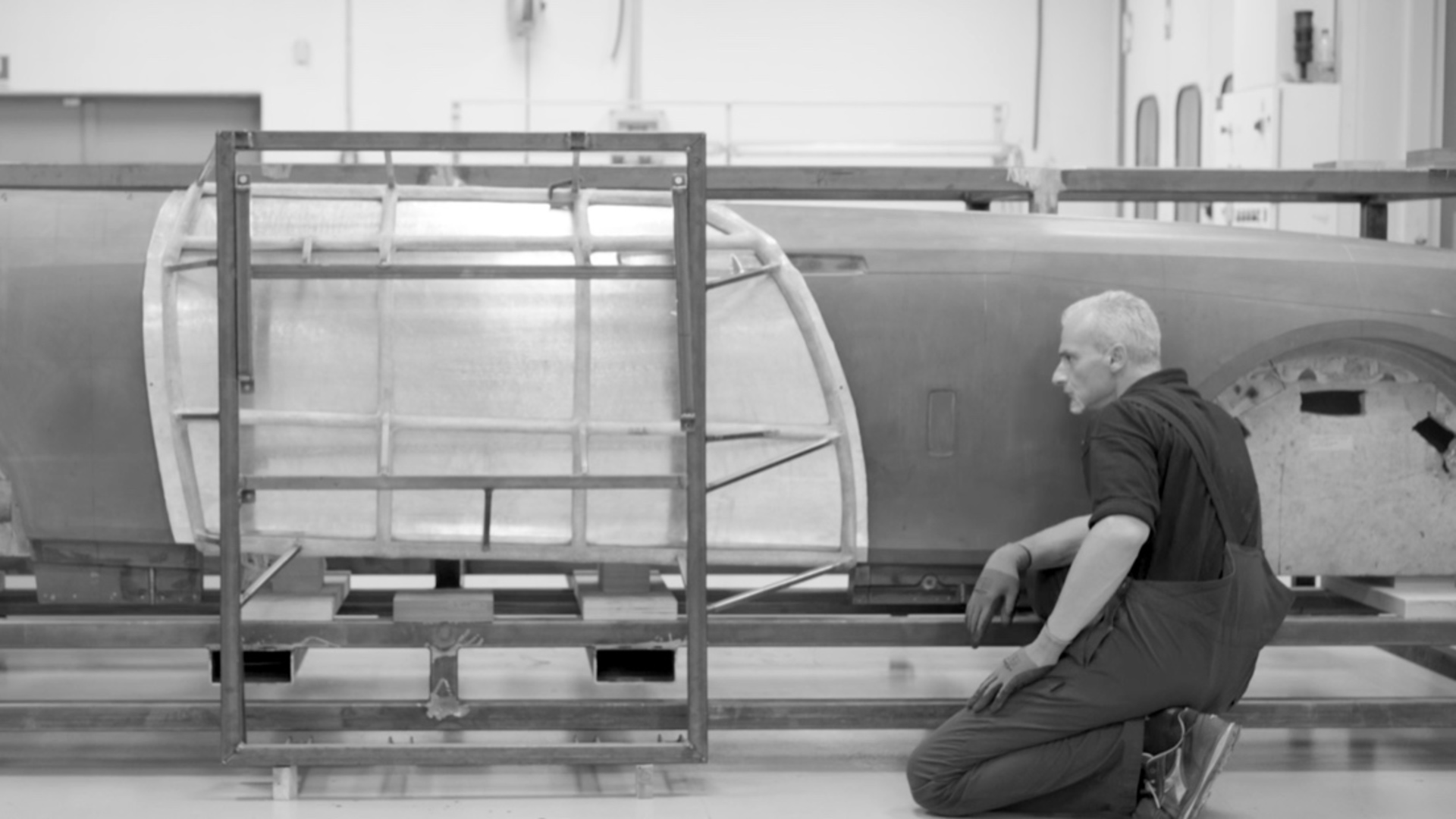black and white image of man reviewing the detail of the car