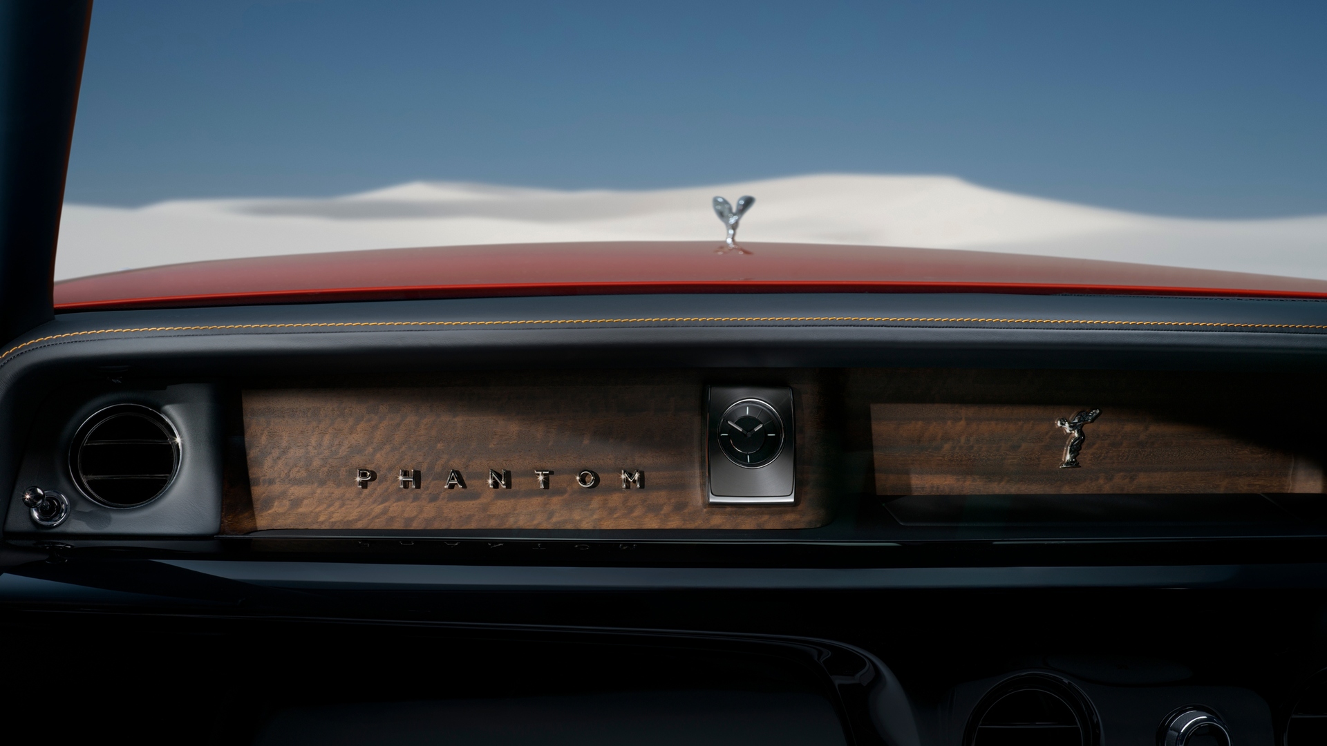 Interior image of the Phantom, looking out the front wind-screen with the SOE and desert in the background. "Phantom" positioned against a wood fascia and interior clock