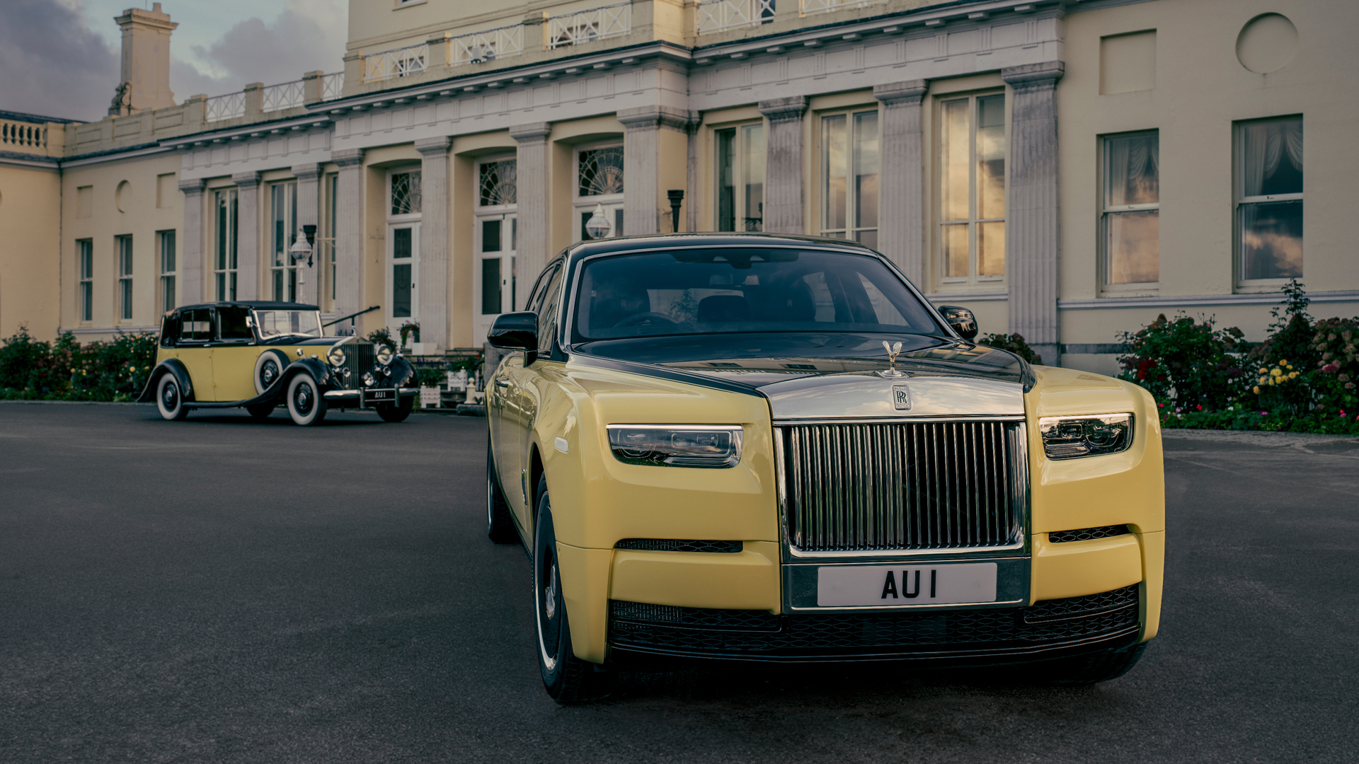 Front angled shot of the 60's Phantom Goldfinger and the new Phantom Goldfinger parked outside of the cream mansion.