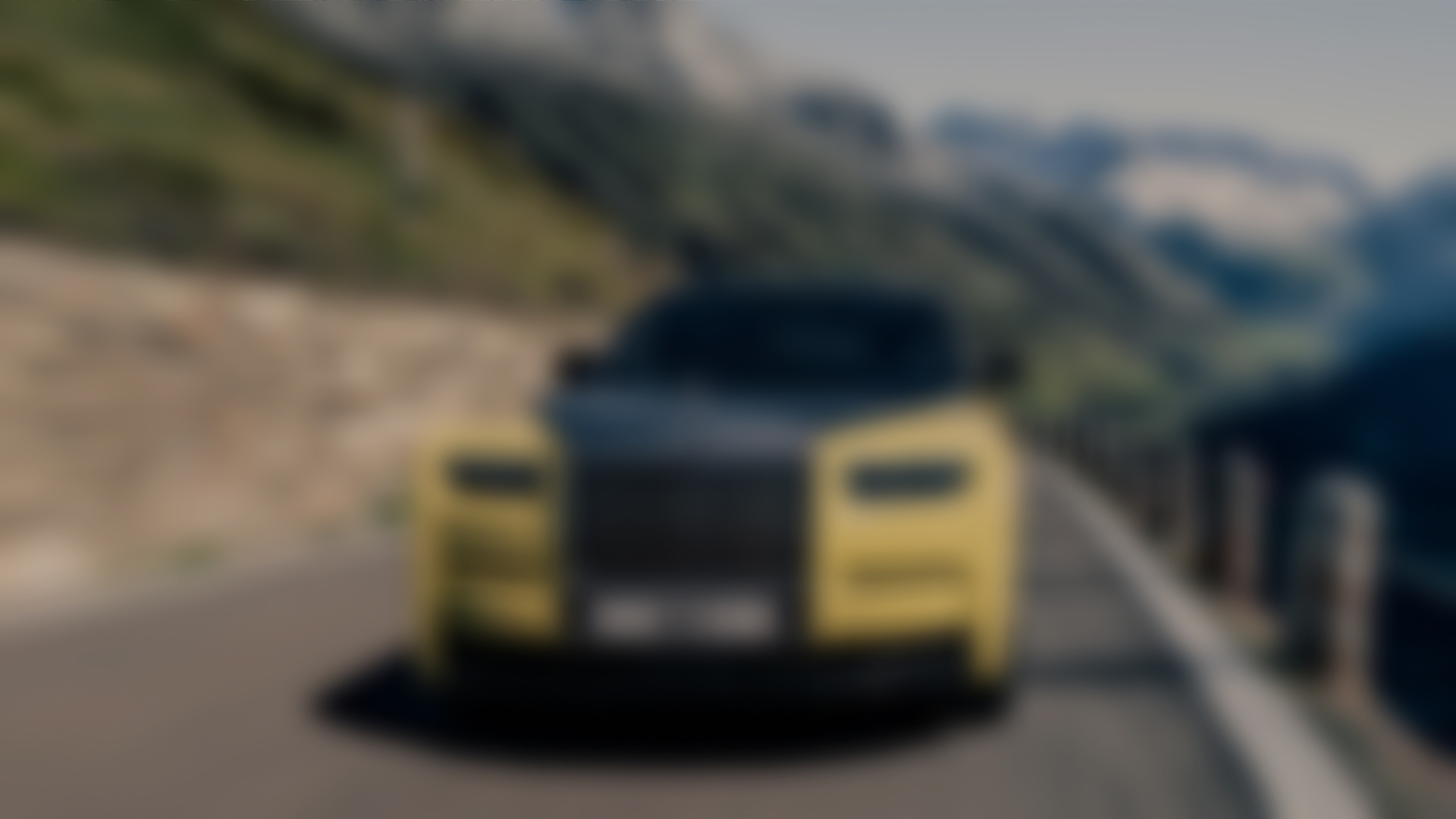 Front angle of the Phantom Goldfinger driving fast through mountains. You can see the front grill, windshield, and beautiful two tones black and yellow.