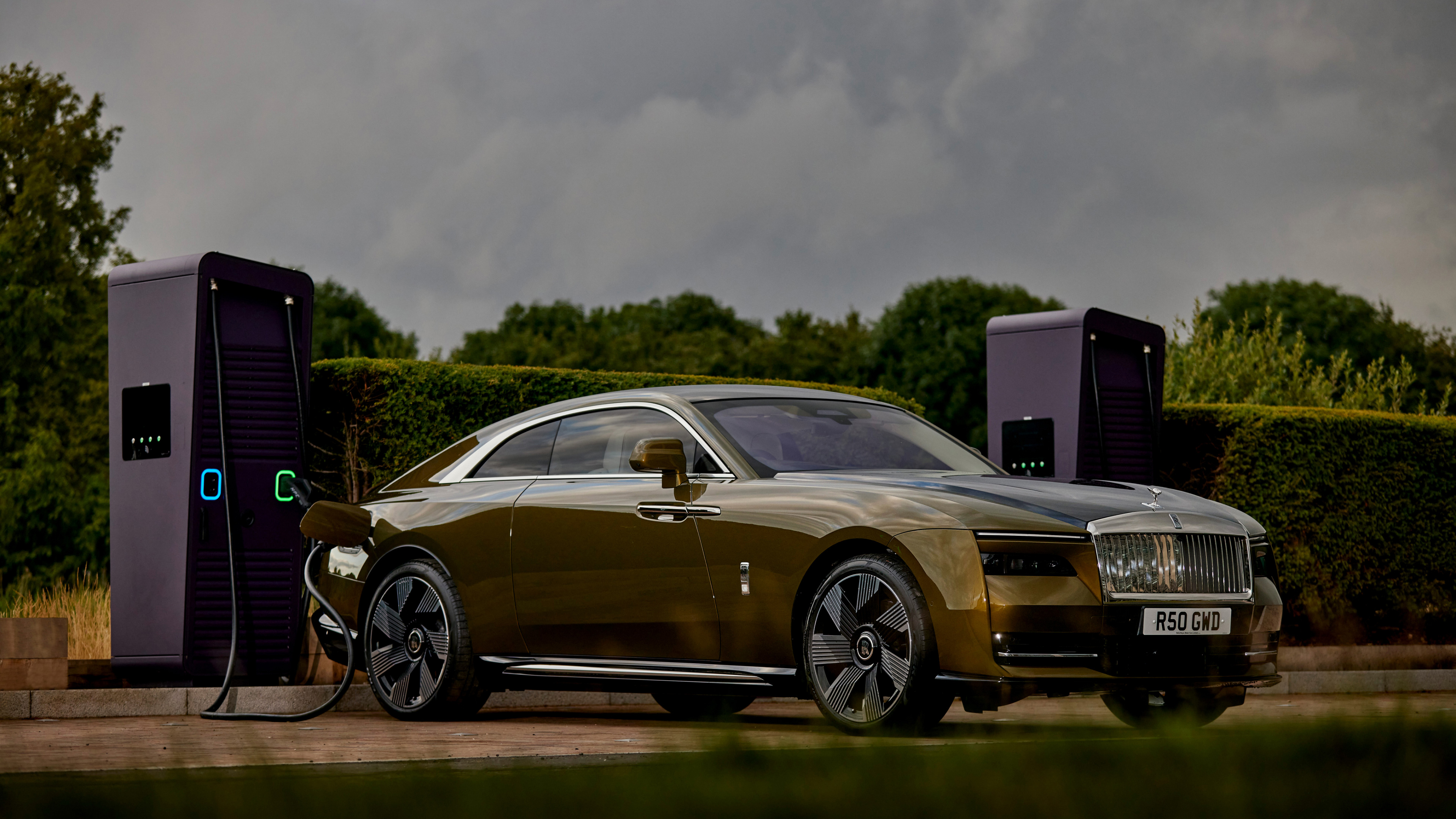 Front three quarter view of Spectre charging at a public charging station