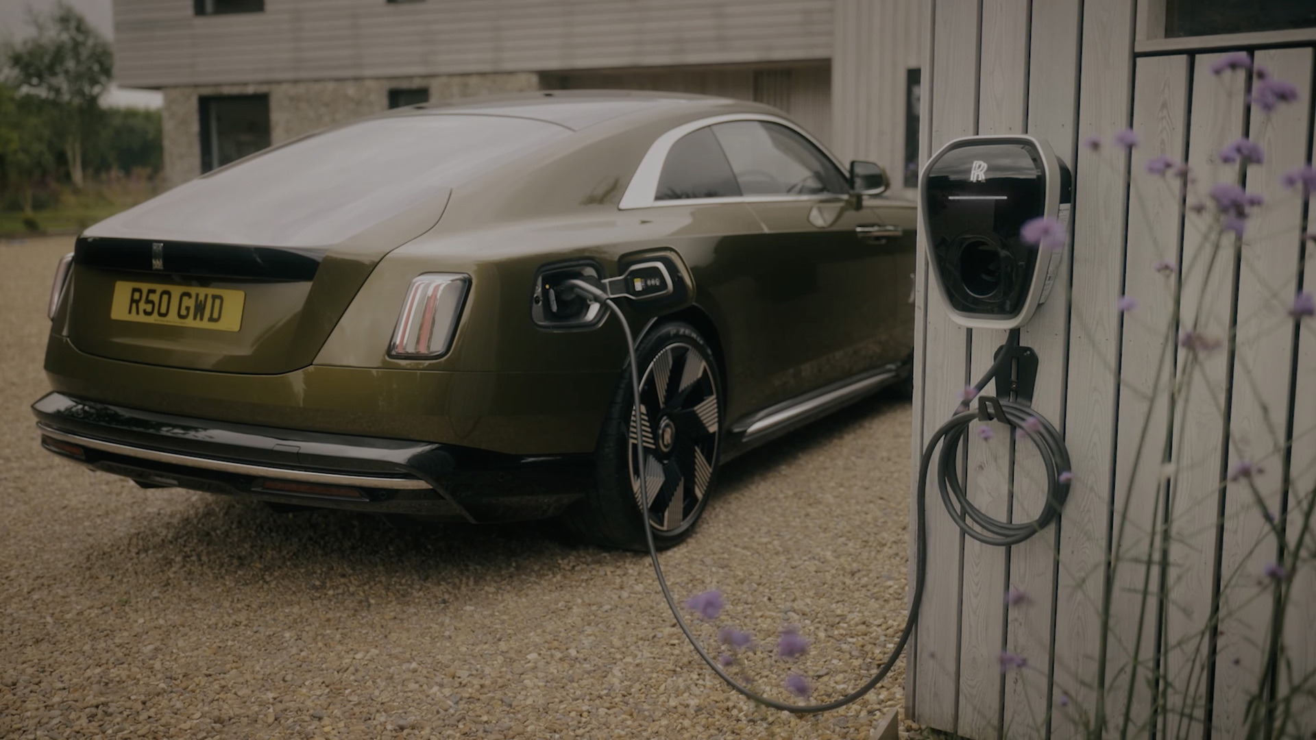 Rear three quarter view of Spectre charging at a private charging location